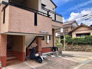 A two-story building with a sign reading "Mid town sakura". - Midtown Sakura Apartment House 201 (Nachikatsuura)