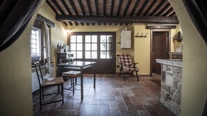 Una cucina rustica con parete in pietra, soffitto in legno e pavimento piastrellato.