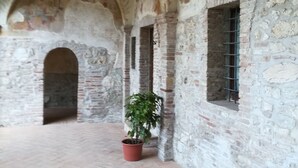 Un interno con pareti in pietra, soffitti a volta e pavimento piastrellato.