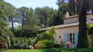 A house with a tiled roof, surrounded by lush greenery and a well-maintained lawn. - A charming, 6-bedroom house in a convenient location (Gassin)