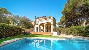 Ein zweistöckiges Haus mit einem Schwimmbecken im Vordergrund.