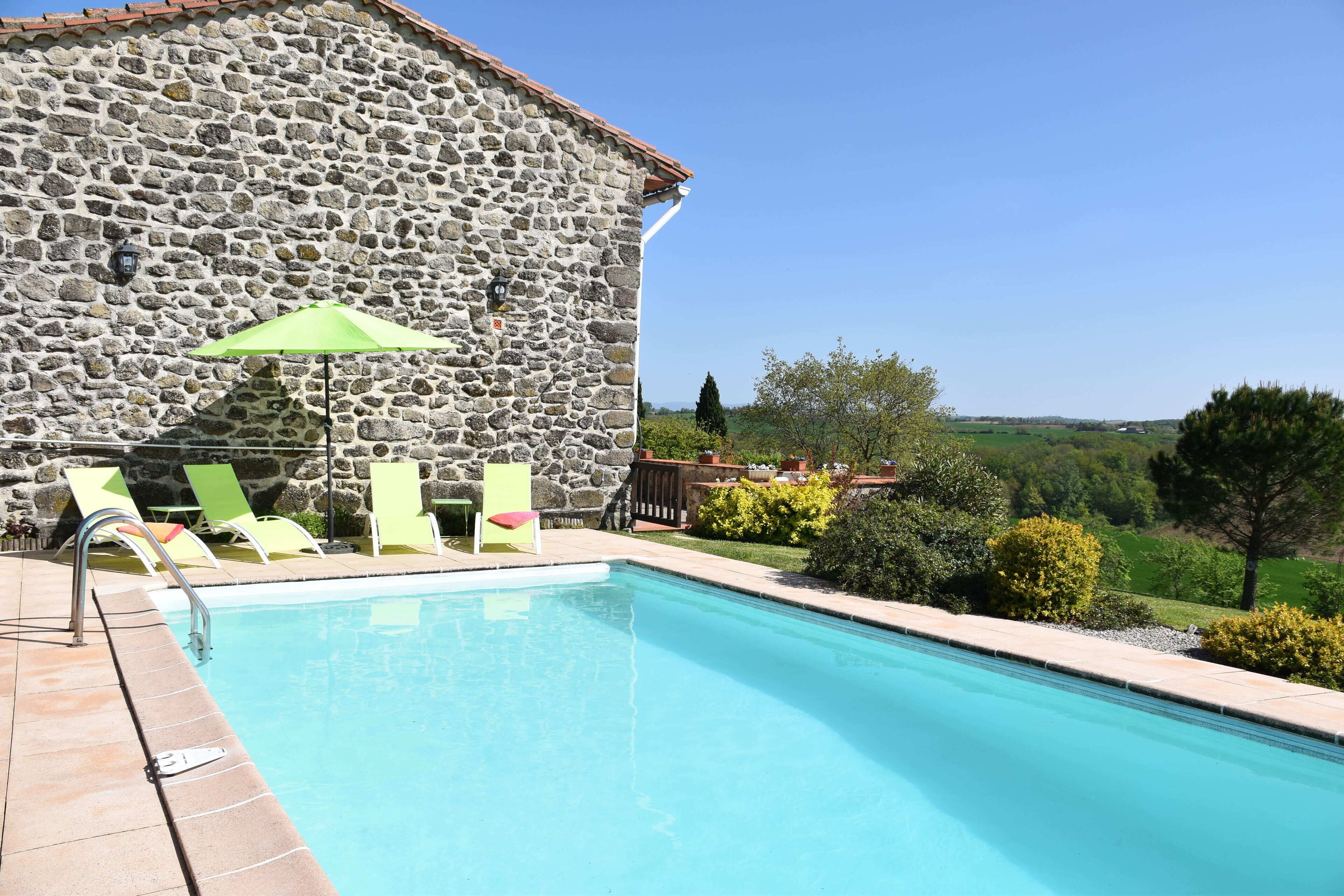 Een buitenzwembad en ligstoelen