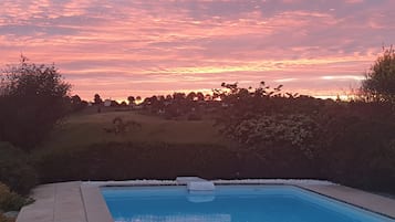 Una piscina al aire libre, tumbonas