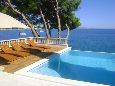 Seafront villa with heated swimming pool, teak deck, open sea view, boat mooring