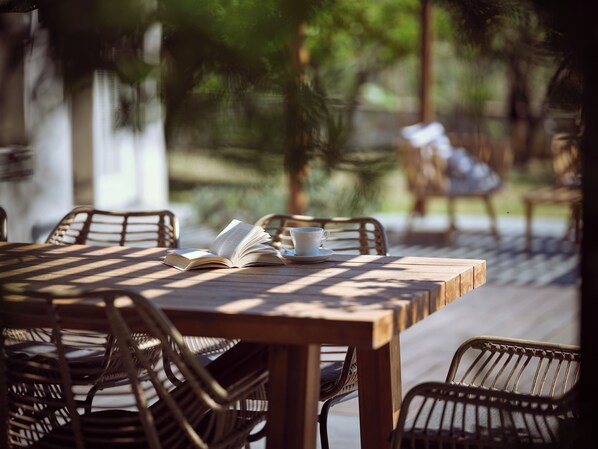 A wooden table with a book, a cup, and a saucer.