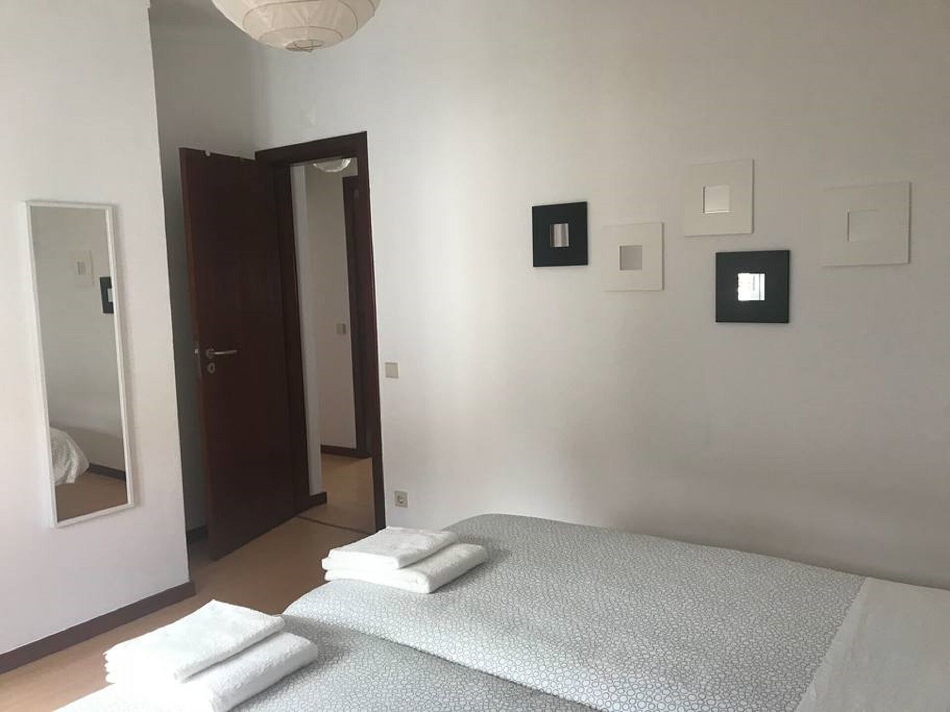 Une chambre d’hôtel avec un lit, une porte et un couloir.