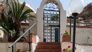 A set of brick stairs leading to a gated entrance with a decorative archway. - Villa Anna with Pool and panoramic terrace. (Costa Saracena - Castelluccio)