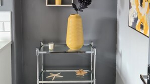 A corner with a gray wall, a glass shelf with decorative items, and a framed artwork. - VICTORIA24: CRAIG Y DON LLANDUDNO
CLOSE TO PROMENADE & VENUE  CYMRU (Llandudno)
