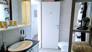 A modern bathroom with a white sink, mirror, and toilet. There is a towel rack with towels and a small plant on the right. - Apartment"View Lux"-sea view,swimming pool, jacyzzi, sauna,garden,playground (Vela Luka)