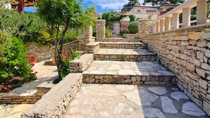 A stone pathway leading up to a stone wall with a railing, surrounded by greenery and trees. - Apartment"View Lux"-sea view,swimming pool, jacyzzi, sauna,garden,playground (Vela Luka)