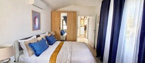 A hotel room with a bed, a wardrobe, a mirror, and a door leading to a bathroom. - Apartment"View Lux"-sea view,swimming pool, jacyzzi, sauna,garden,playground (Vela Luka)