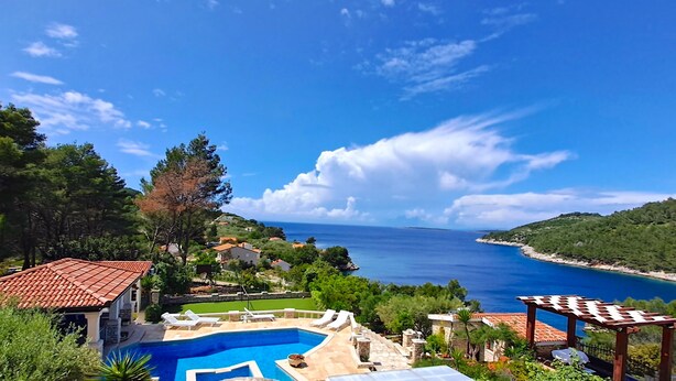 A pool area with a view of the sea, surrounded by greenery and buildings. - Apartment"View Lux"-sea view,swimming pool, jacyzzi, sauna,garden,playground (Vela Luka)