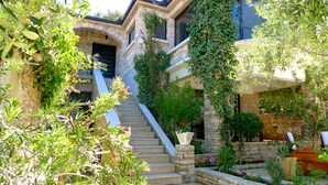 A stone staircase leading to a house with a stone facade and a garden with various plants and flowers. - Apartment"View Lux"-sea view,swimming pool, jacyzzi, sauna,garden,playground (Vela Luka)