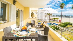 A balcony with a dining table set for four, outdoor chairs, and a small pool area. - Cosy apartment for 4 people with WIFI, A/C, TV and patio (Alcúdia)