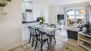 A modern apartment with a dining area, kitchen, and living room. - Cosy apartment for 4 people with WIFI, A/C, TV and patio (Alcúdia)