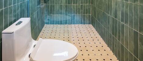 Un área de ducha pequeña y cerrada, con techo de madera y paredes de azulejos verdes.