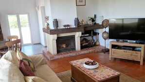 A spacious living room with a fireplace, a television, and a comfortable seating area. - Villa with large pool, mountain&ocean view-near beaches&Lisbon  (Sesimbra)