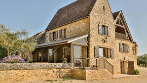 A stone house with a sloped roof, large windows, and a balcony. - Beautiful Perigourdine house 12 km from Sarlat, Montignac-Lacaux, Les Eyzies (Tamniès)