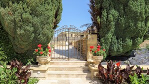 A stone staircase leading to a gated entrance with a wrought iron gate, surrounded by lush greenery and potted plants. - Beautiful Perigourdine house 12 km from Sarlat, Montignac-Lacaux, Les Eyzies (Tamniès)