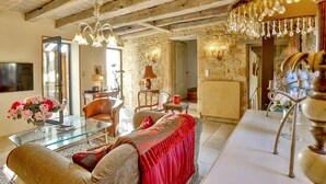 A cozy living room with a glass coffee table, leather sofa, and a red throw blanket. There is a stone wall and a wooden ceiling. - Beautiful Perigourdine house 12 km from Sarlat, Montignac-Lacaux, Les Eyzies (Tamniès)