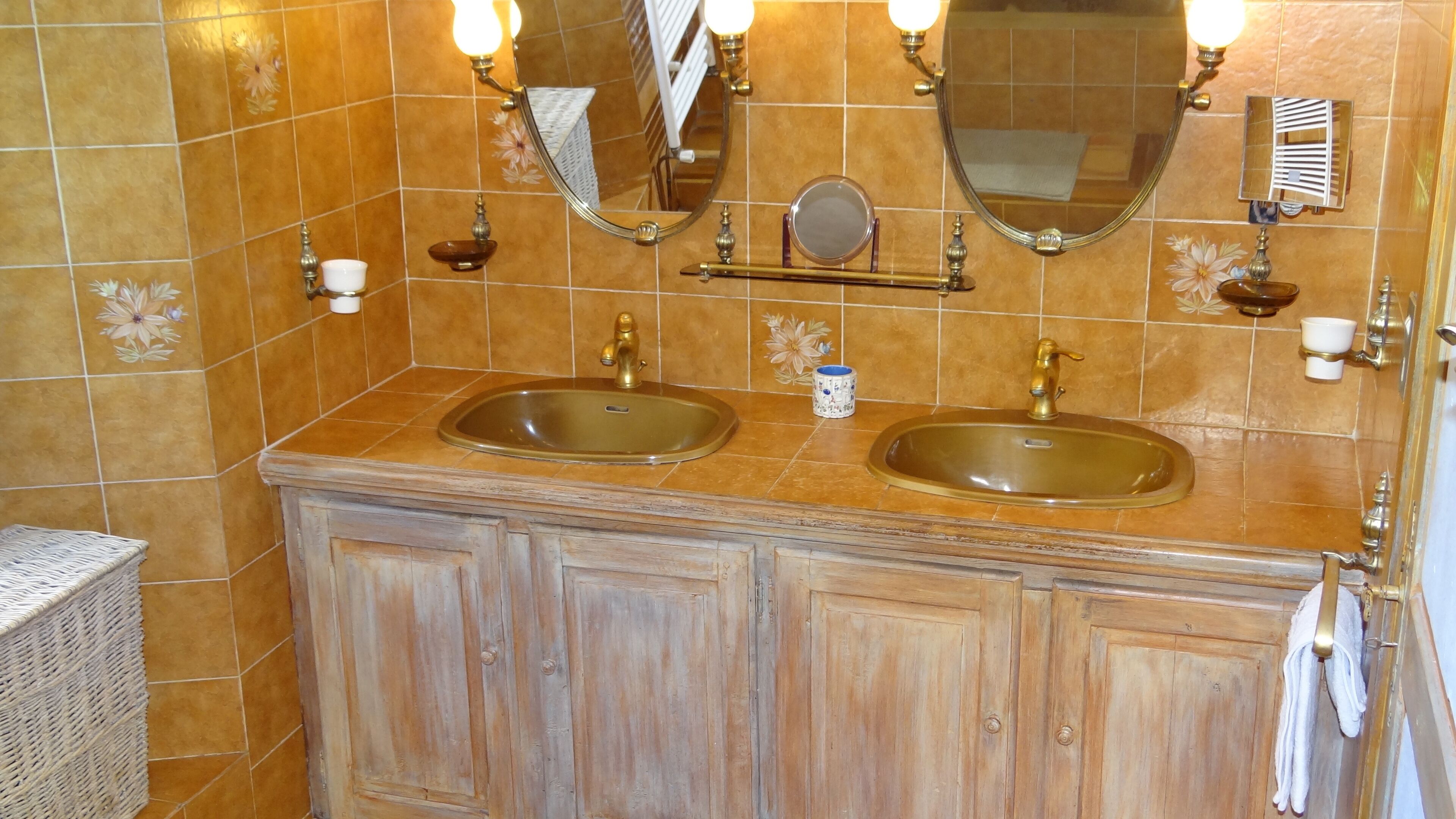 A bathroom with two sinks, a mirror, and a towel rack.