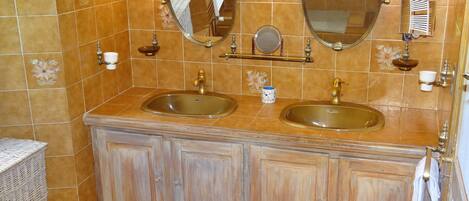 A bathroom with two sinks, a mirror, and a towel rack.
