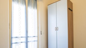 A bedroom with a bed, a wardrobe, and a window with curtains. - M029 - Marcelli, new seafront two-room apartment with terrace (Marcelli)