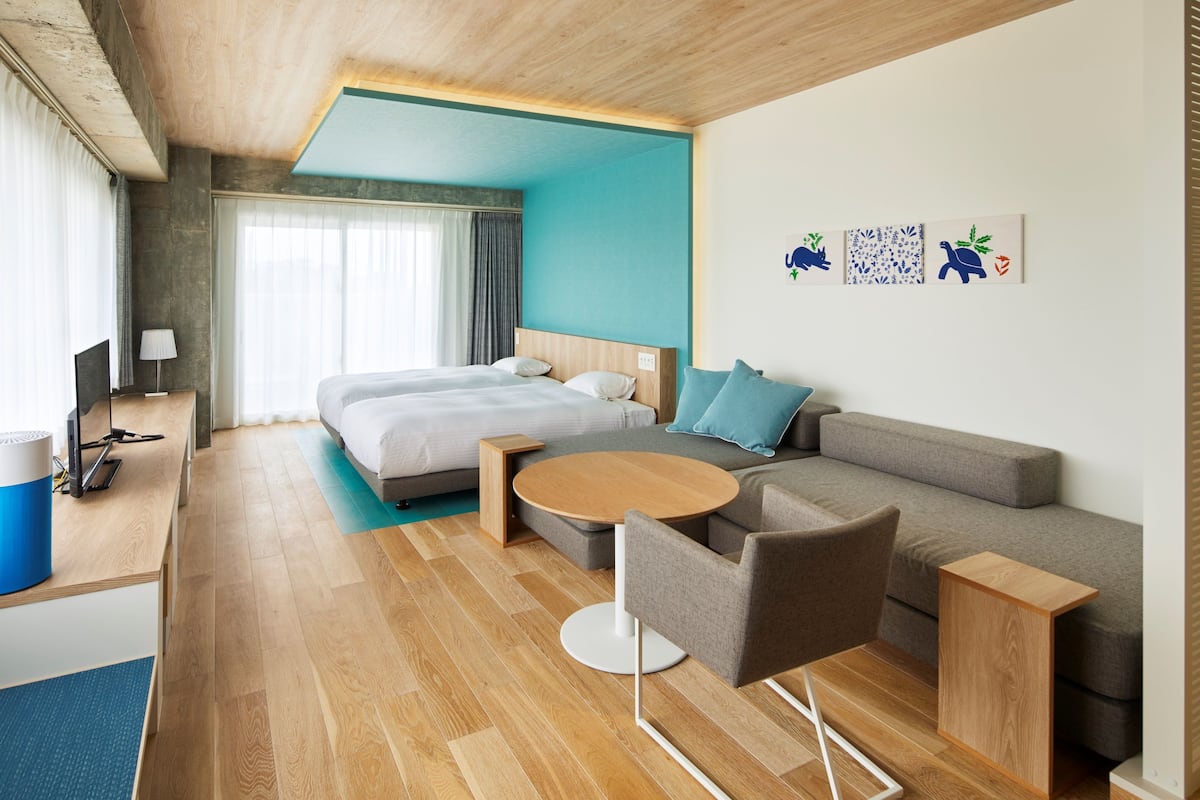 Une chambre d’hôtel moderne avec un lit, un canapé et une table ronde.
