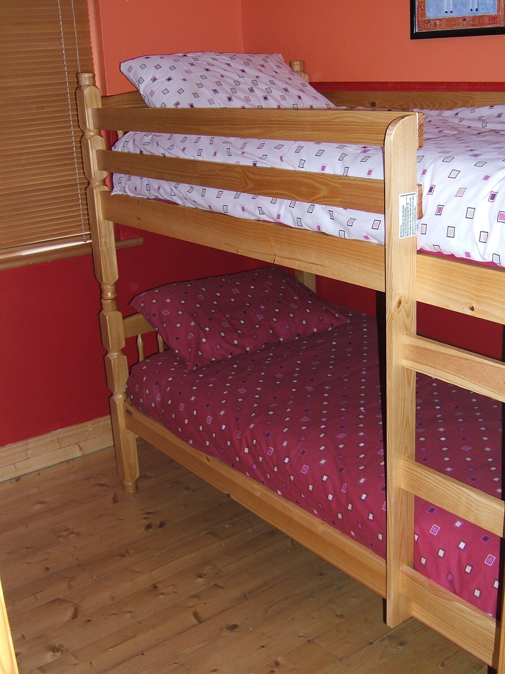 Un letto a castello con due piani, ognuno con una coperta fantasia.