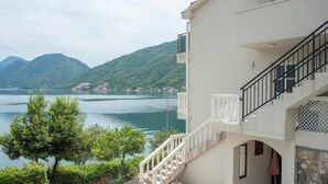 Un edificio con una escalera que conduce a un balcón con vistas a un lago y montañas.