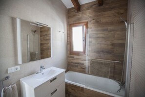 Een bad/douchecombinatie, een haardroger, een bidet, handdoeken