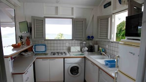 Una cocina compacta con lavadora, estufa y fregadero.