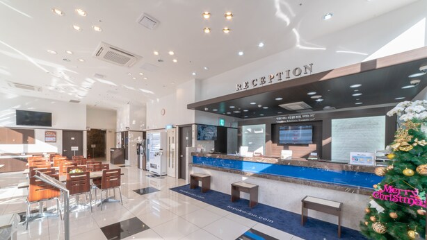 A hotel reception area with a reception desk, seating area, and a Christmas tree. - Toyoko Inn Seoul Dongdaemun No.2 (Seoul)