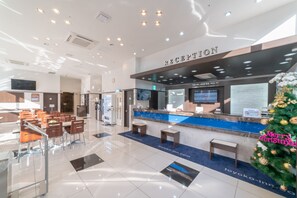 A hotel reception area with a reception desk, seating area, and a Christmas tree. - Toyoko Inn Seoul Dongdaemun No.2 (Seoul)