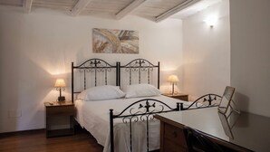 Un dormitorio con cama, mesitas de noche, un espejo y un cuadro en la pared.