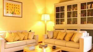 Una sala de estar con dos sofás, una mesa de centro, una lámpara y una estantería.