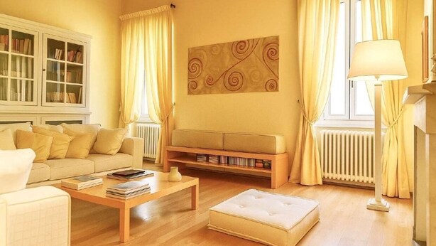 Una sala de estar con sofá, mesa de centro y estantería.