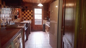 Una cocina con armarios de madera, un lavamanos y un ventanal.