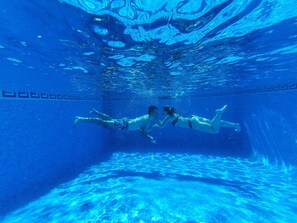Vista subacuática de una piscina con dos personas nadando.