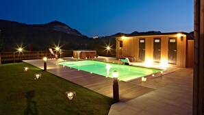 A swimming pool with a wooden deck, a hot tub, and a wooden building with large windows. - Spectacular designer house, with heated pool, 8 minutes from the beach. (Ea)