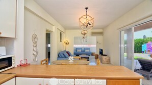 Una cocina moderna con encimera de madera, microondas y un atrapasueños en la pared.