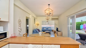 A modern kitchen with a wooden countertop, a microwave, and a dreamcatcher on the wall. - Huge Villa in the Heart of Coral Bay Paphos,100m to Beach Large Pool -Sleeps 15 (Pegeia)