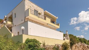 Un immeuble à plusieurs étages, doté de balcons, d’une cheminée et d’une façade en pierre.