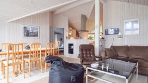 A spacious living area with a sofa, a glass coffee table, and a bean bag. There is a dining table with chairs and a kitchen area in the background. - 3 bedroom cozy home in Humble (Humble)