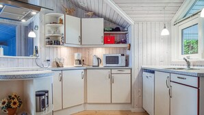 A kitchen with white cabinets, a microwave, a kettle, and a sink. - 3 bedroom cozy home in Humble (Humble)