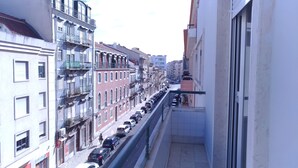 Une rue étroite, bordée de voitures garées et d’immeubles des deux côtés.