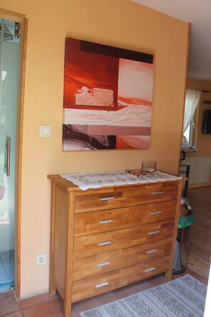 Comfortable room with a dresser, abstract art, and a patterned rug.