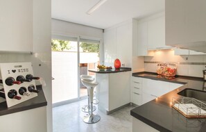 Enjoy a stylish kitchen with a wine rack, coffee machine, and fruit bowl, offering a view of the outdoors.