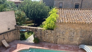 A swimming pool with a stone wall and a tiled roof in the background. - Ulla, Alt Emporda: Holiday home in a small, quiet historic village.  (Ulla, Torroella de Montgri)