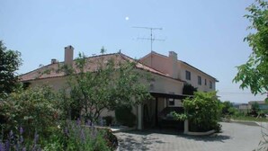 A residential building with a tiled roof, a visible antenna, and a paved driveway. - Caetano Rustic House - West of Portugal (Chã da Laranjeira)